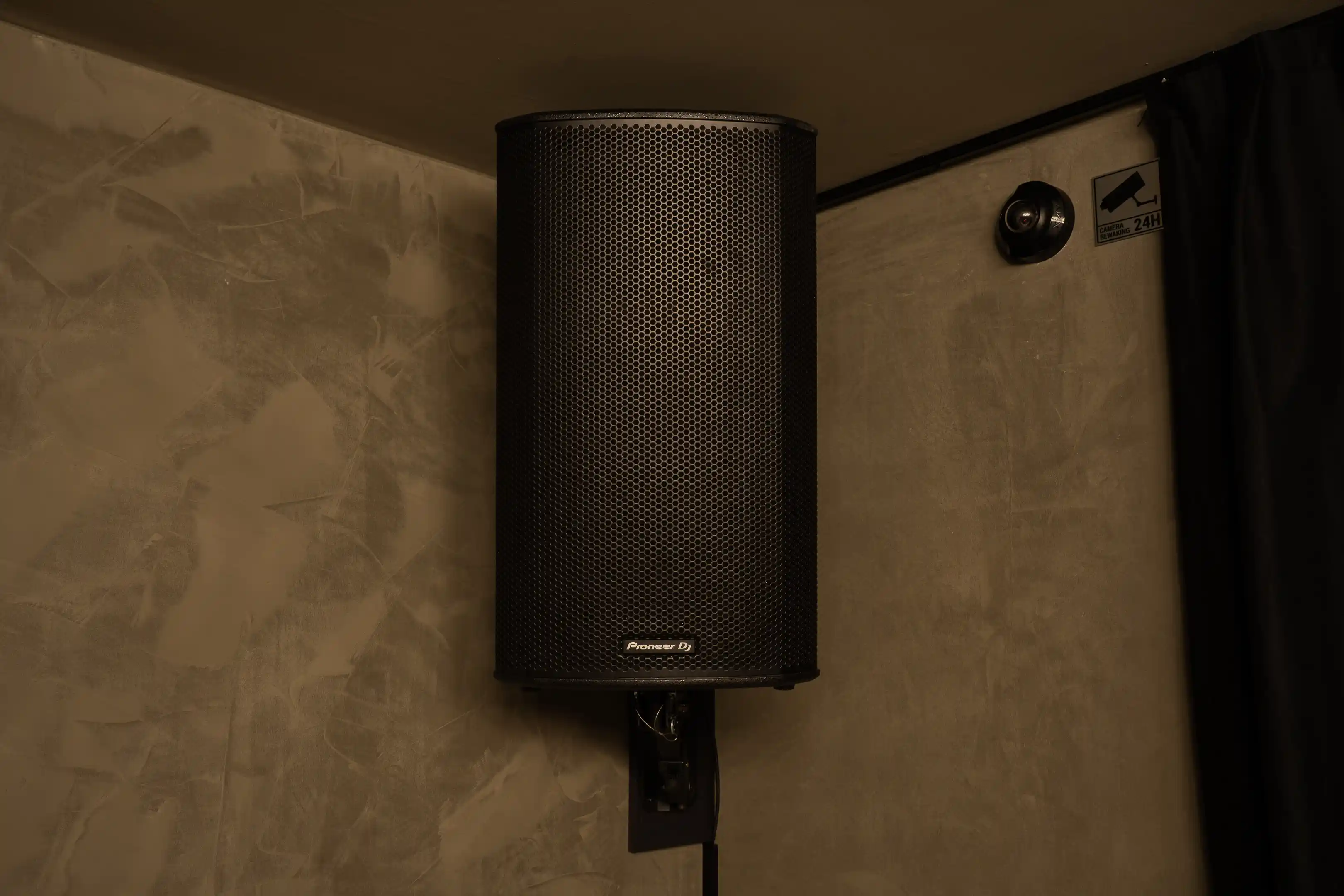 Een Pioneer DJ-speaker hoog aan de muur van de studio