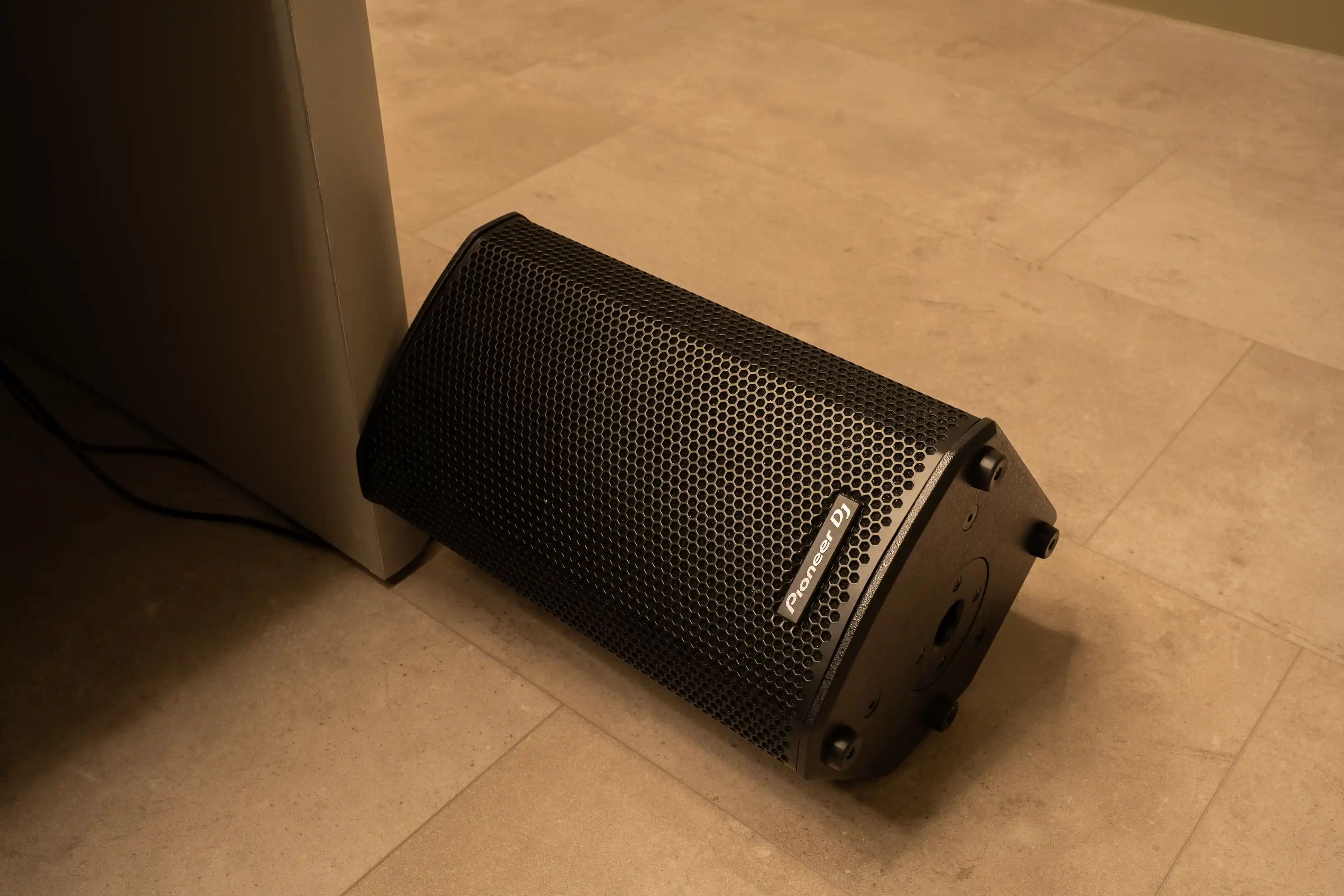 Een Pioneer DJ-monitorspeaker op de vloer naast de booth