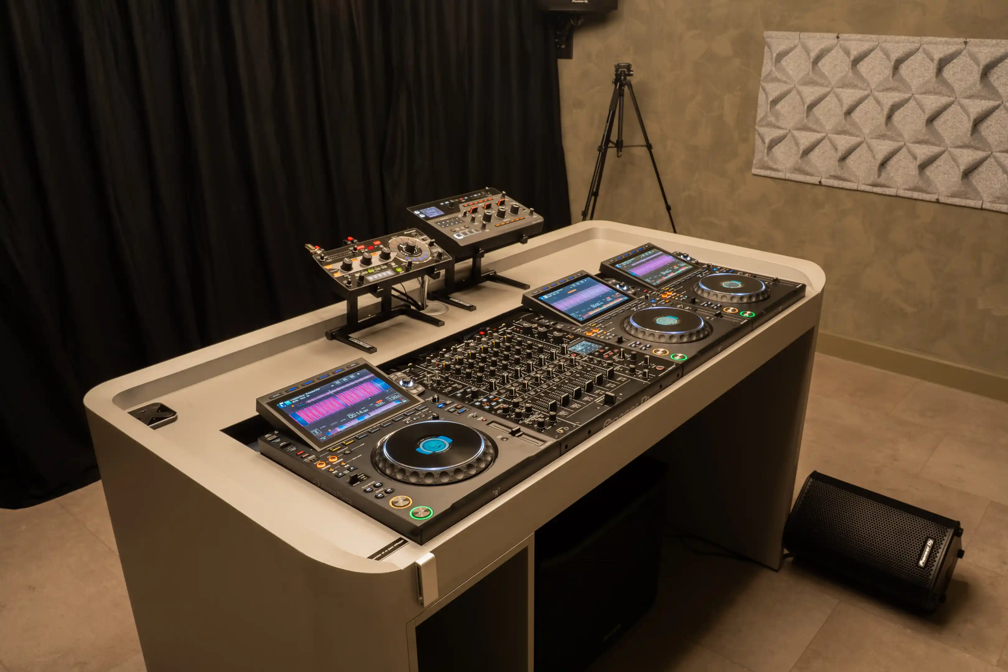 De DJ-booth van opzij met de CDJ's, de mixer en de effect units
