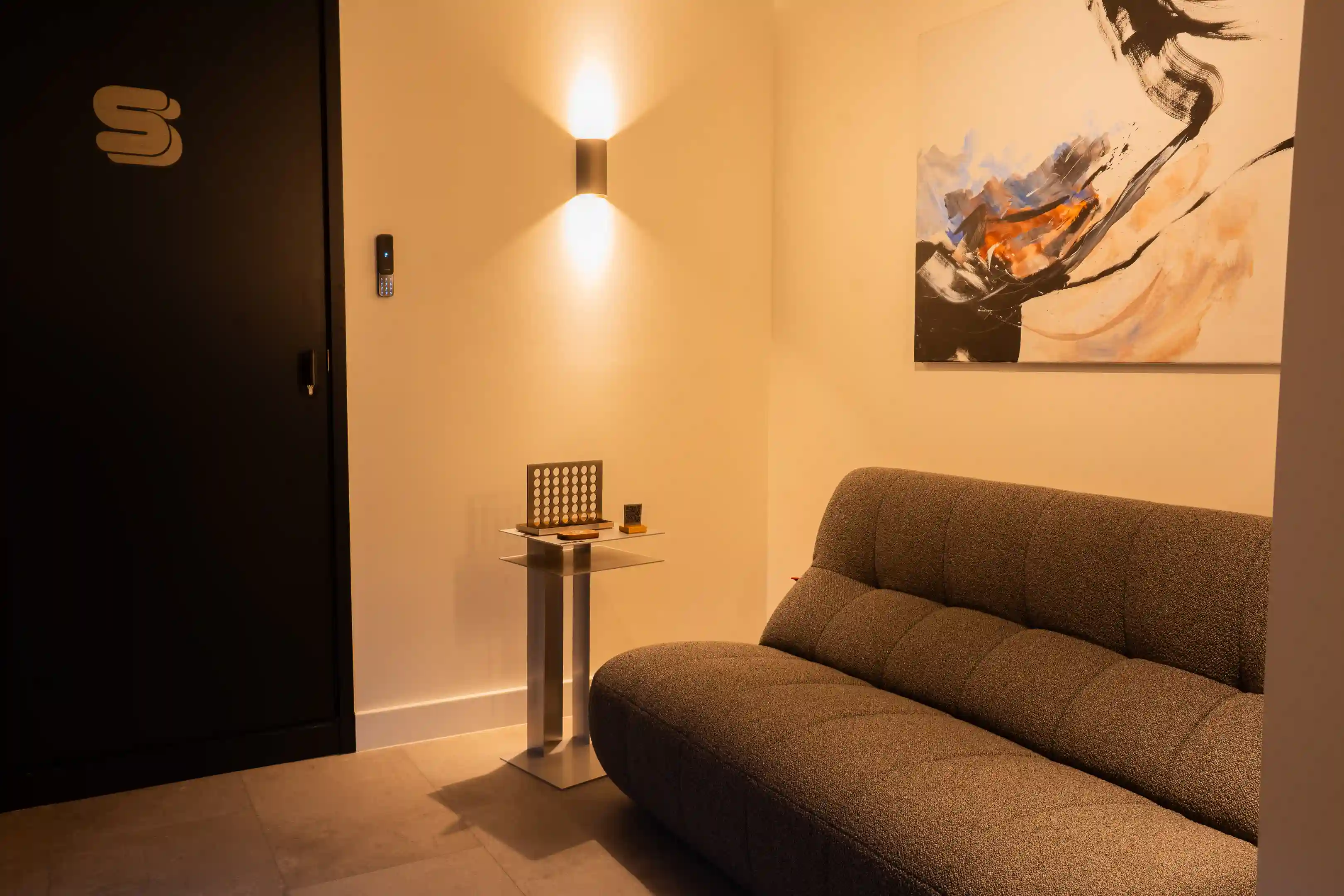 De lounge met een bank en een schilderij aan de muur